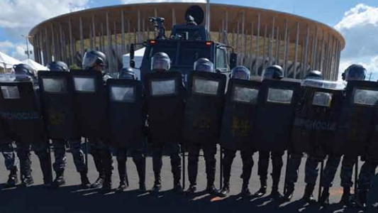Fila de policiais com escudo bloqueia visão de estádio